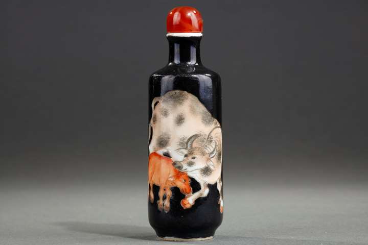 Porcelain snuff bottle decorated with a buffalo and its baby on a black background